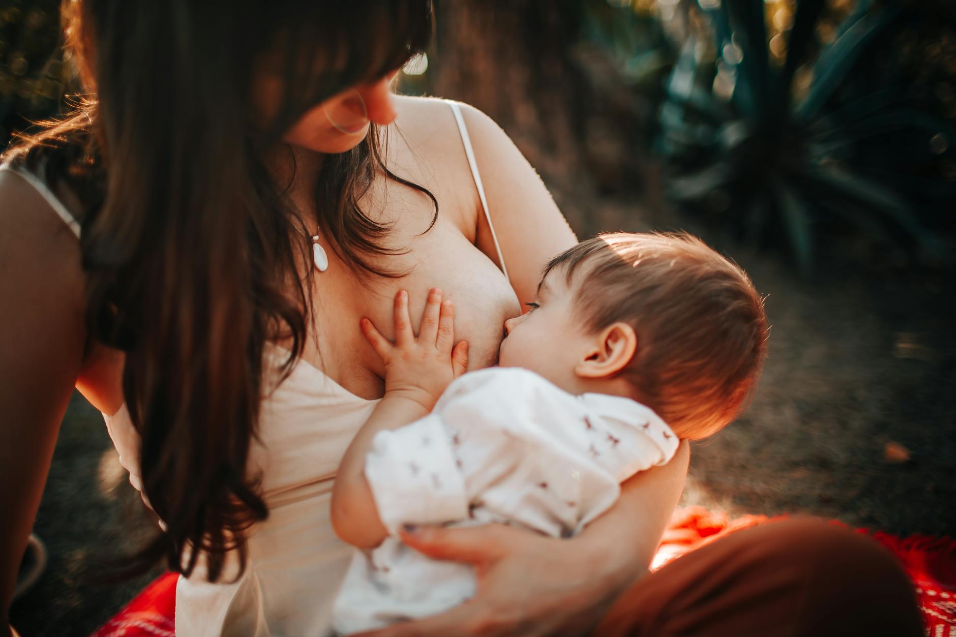Mama karmiąca piersią niemowlę na świeżym powietrzu
